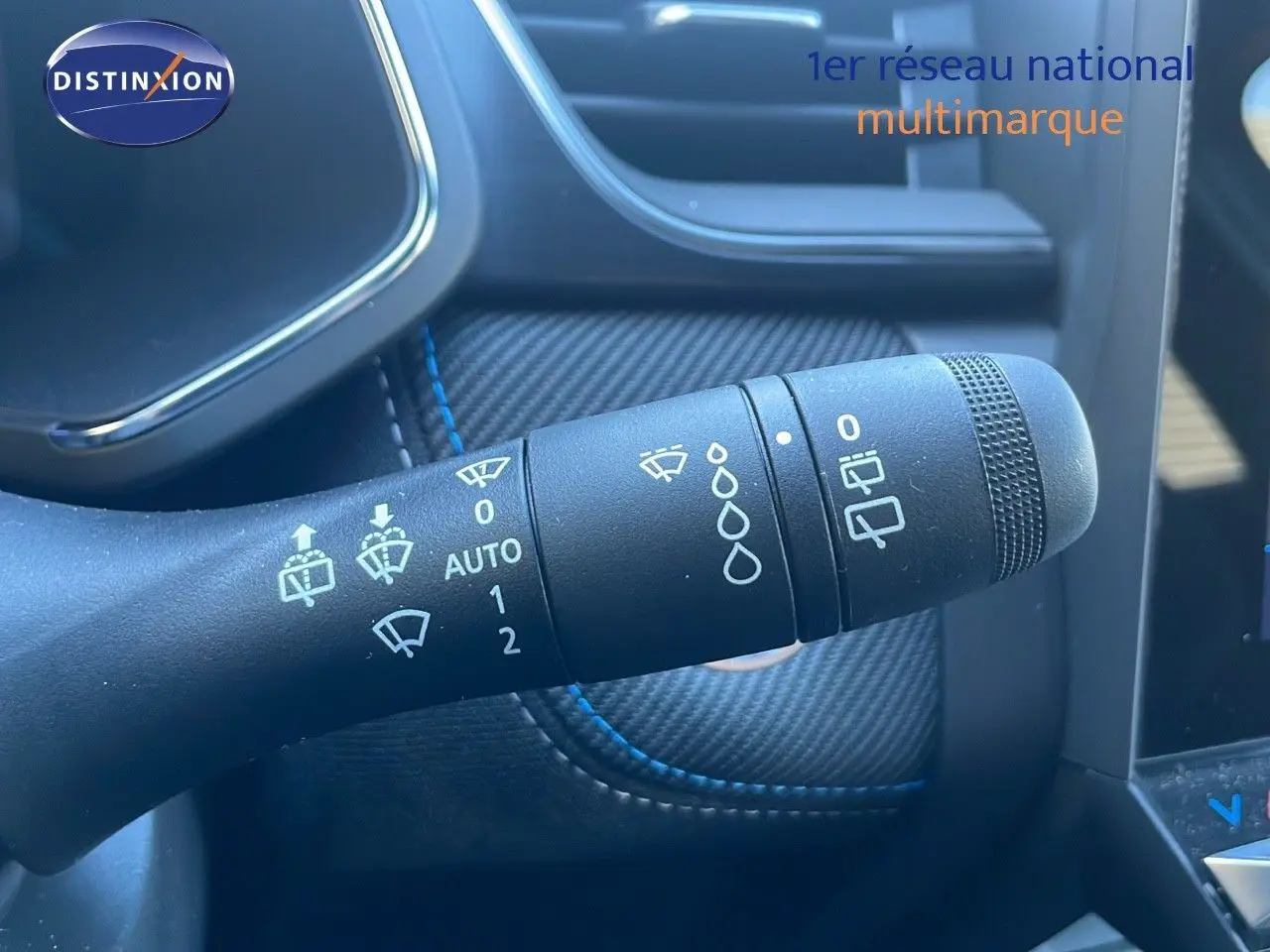 Gros plan sur la commande d’essuie-glace du Renault Symbioz bleu iron metal, avec détails des réglages visibles.