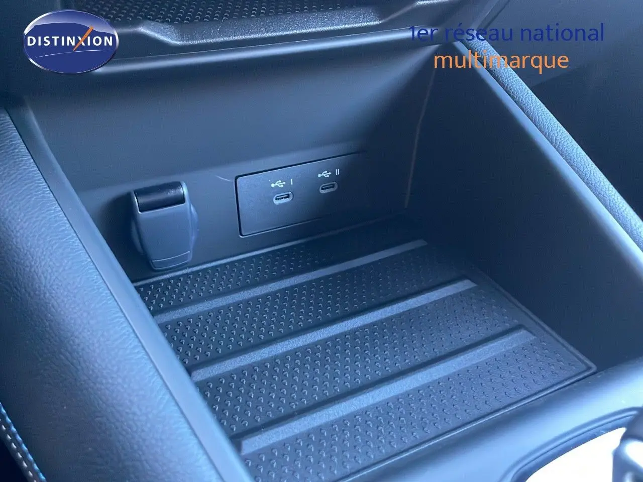 Gros plan sur la console centrale noire avec ports USB-C doubles et prise 12V du Renault Symbioz bleu Iron Metal.