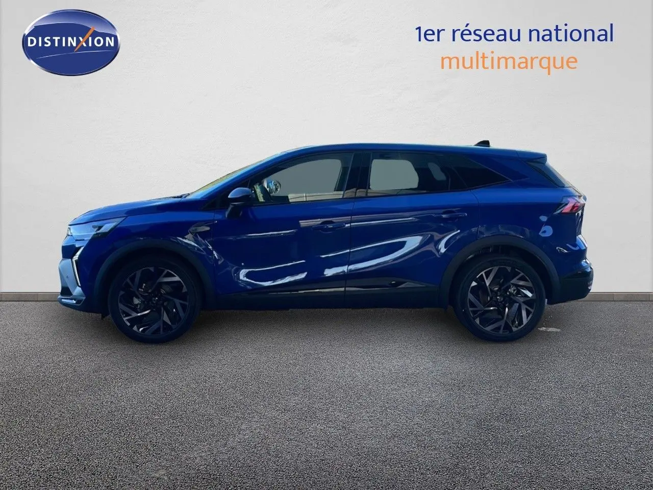Vue latérale droite d'un Renault Symbioz bleu iron metal 2025, SUV hybride avec jantes foncées et lignes dynamiques.