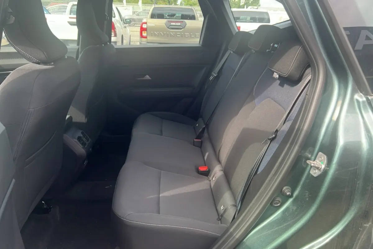 Vue intérieure côté droit sur la banquette arrière du Dacia Bigster vert cèdre 2025 avec sièges en tissu gris.