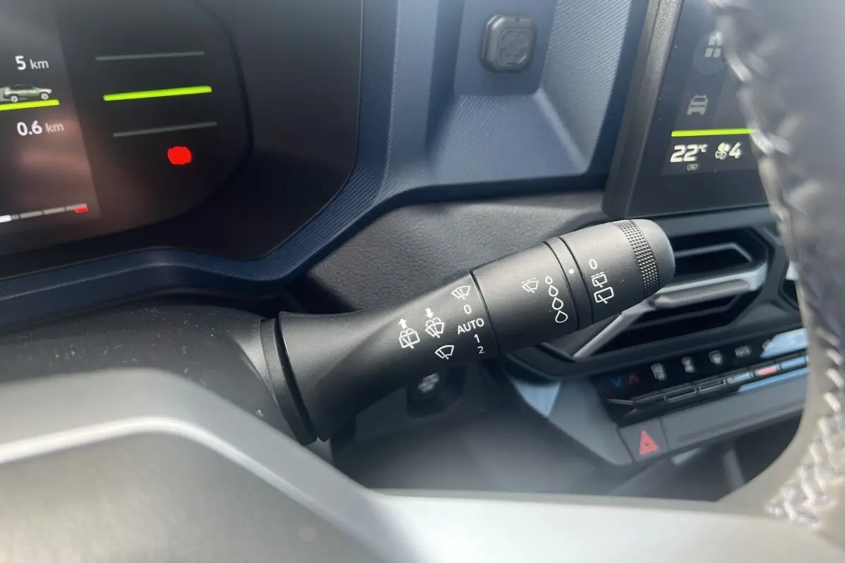 Gros plan sur la commande d’essuie-glace à gauche du volant dans l’habitacle du Dacia Bigster 2025 vert cèdre.