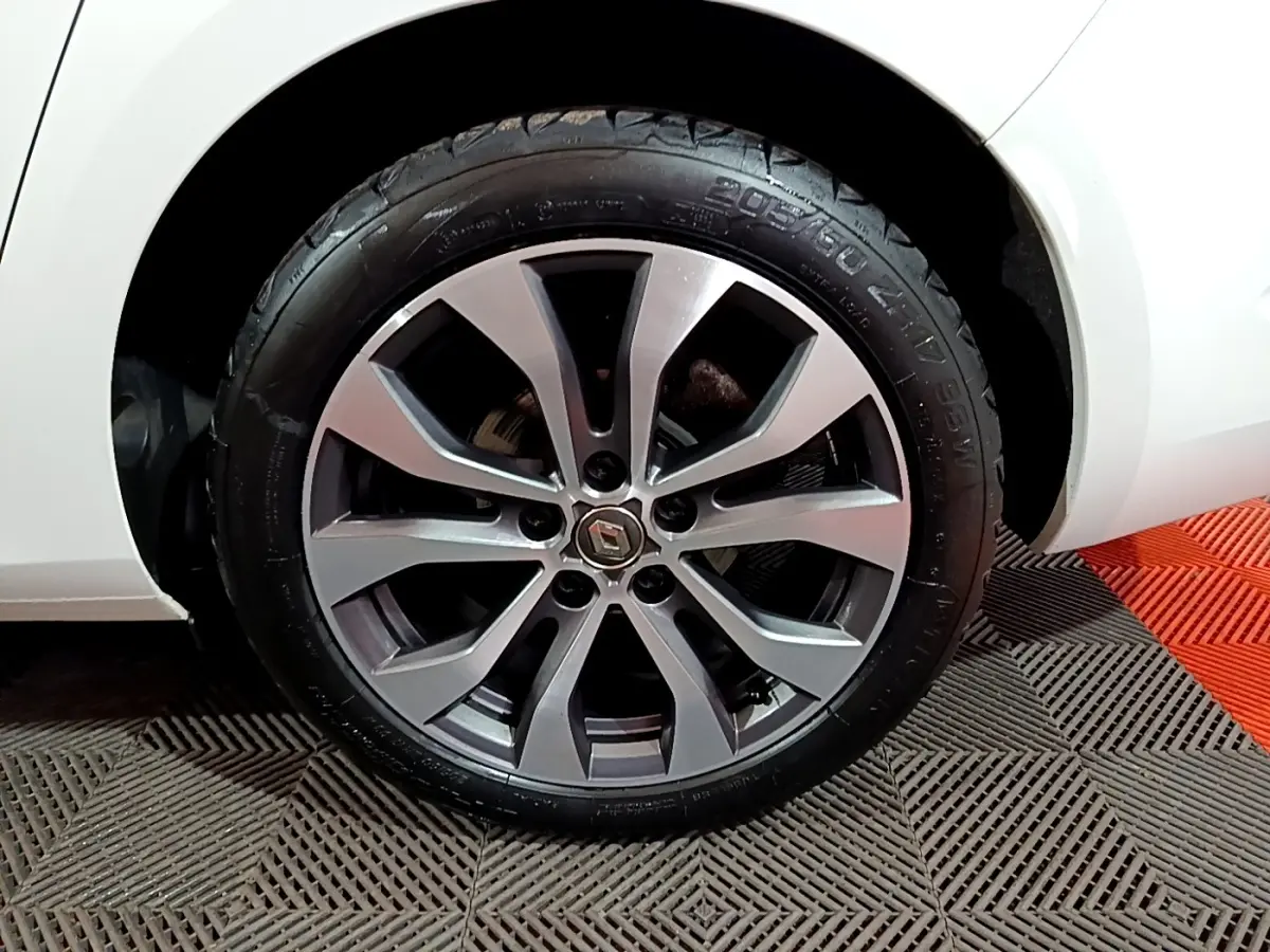 Gros plan sur la roue avant droite de la Renault Mégane blanche 2023 avec jante alliage moderne.