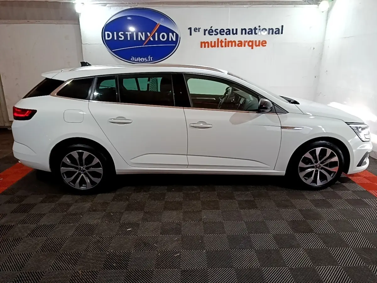 Renault Mégane Techno TCe 140 blanc vue de profil côté gauche, avec jantes alliage et feux arrière LED allumés.