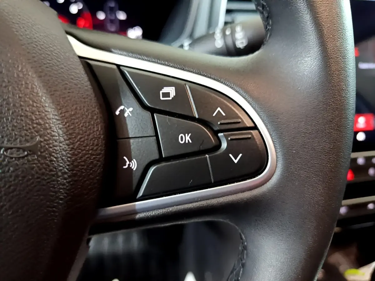 Gros plan sur les commandes multifonctions noires du volant côté gauche de la Renault Mégane Techno TCe 140 EDC 2023.