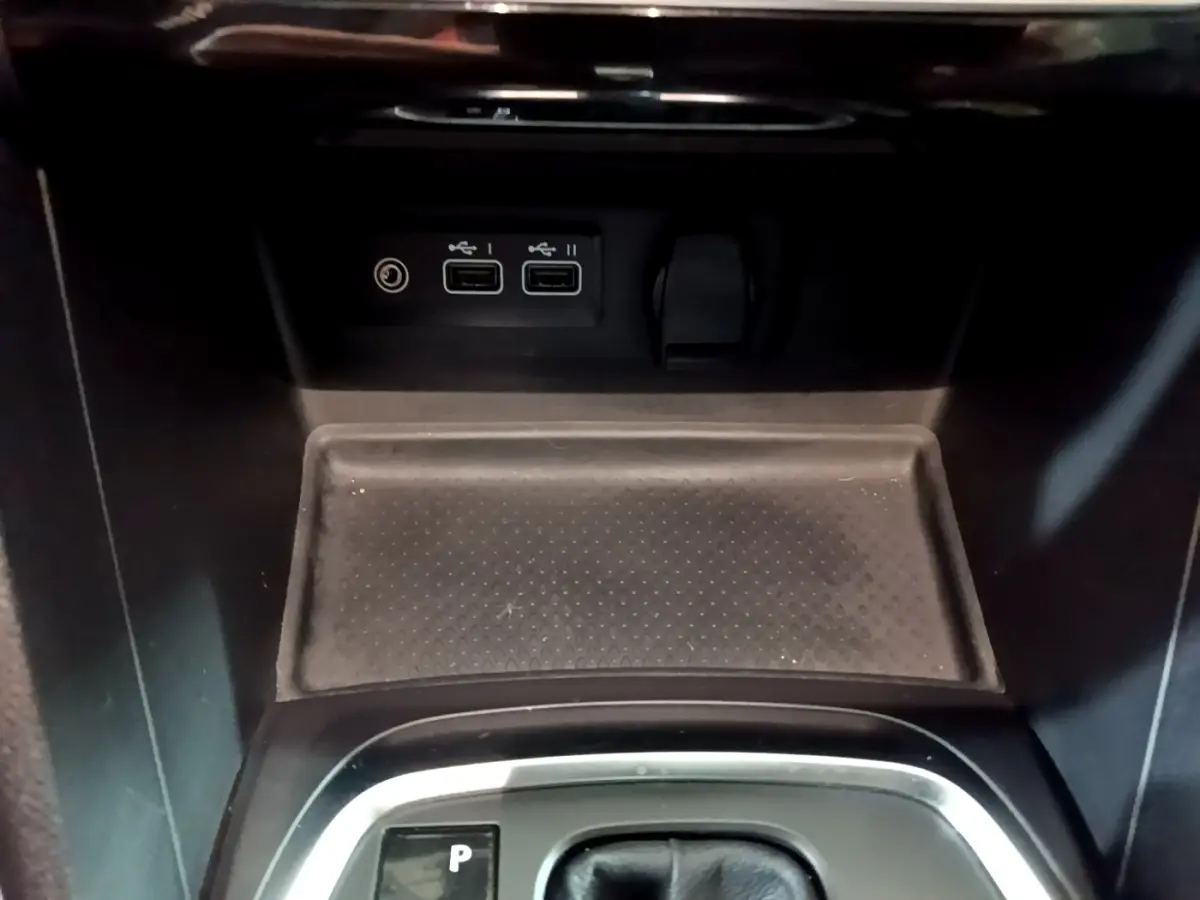 Gros plan sur la console centrale noire de la Renault Mégane Techno 2023 avec ports USB et prise 12V visibles.