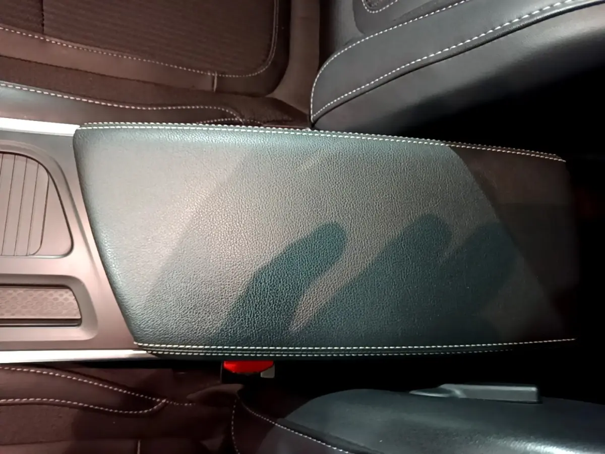 Vue rapprochée de l'accoudoir central noir avec surpiqûres blanches de la Renault Mégane Techno TCe 140 EDC 2023.