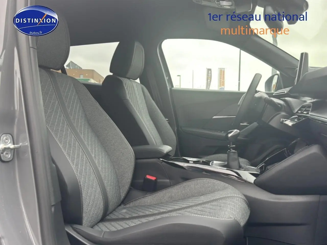 Vue intérieure côté gauche du Peugeot 2008 1.2 100 Allure gris sélénite, mettant en valeur les sièges en tissu embossé.