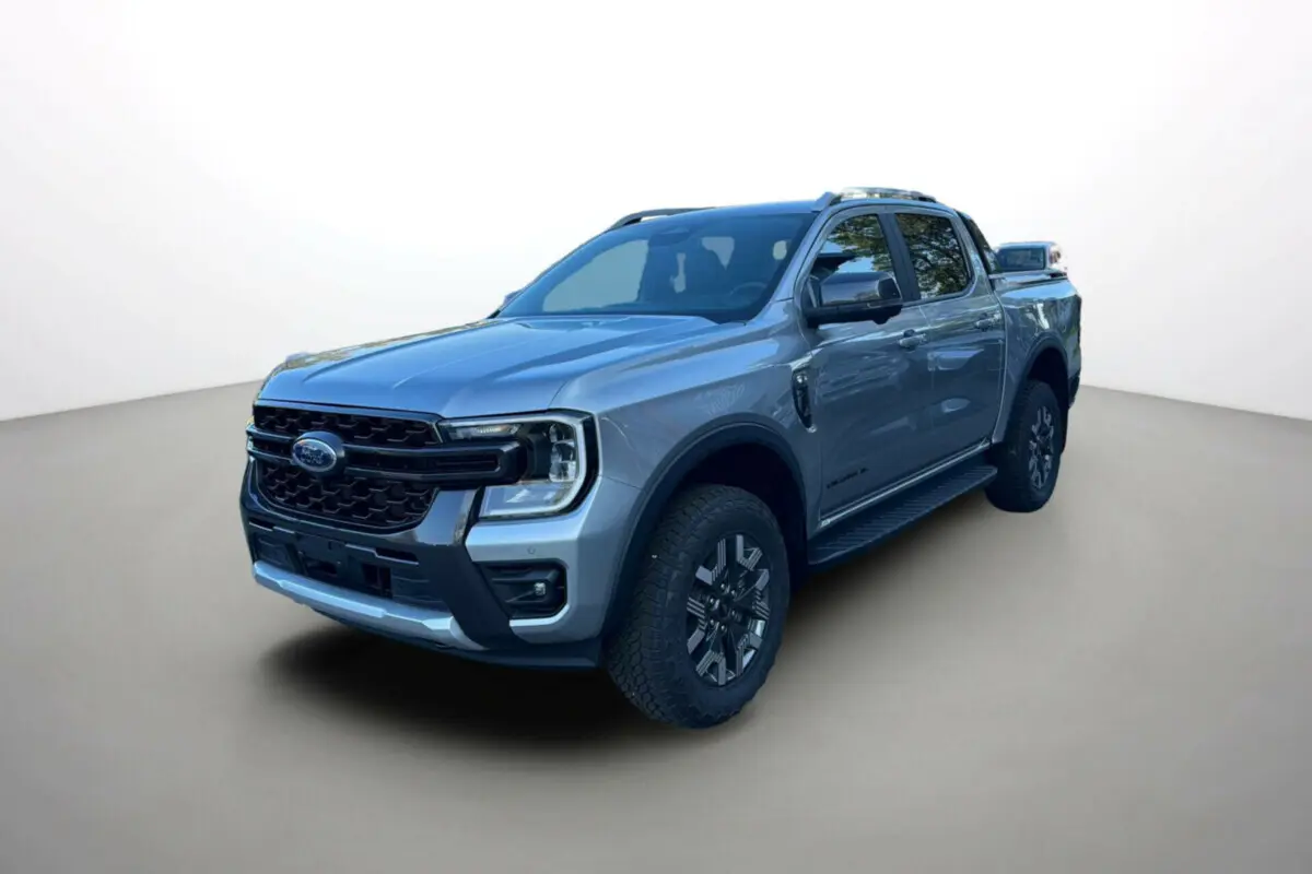 Ford Ranger PHEV gris iconic en 3/4 avant droit avec jantes alu et barres de toit visibles sur fond neutre.