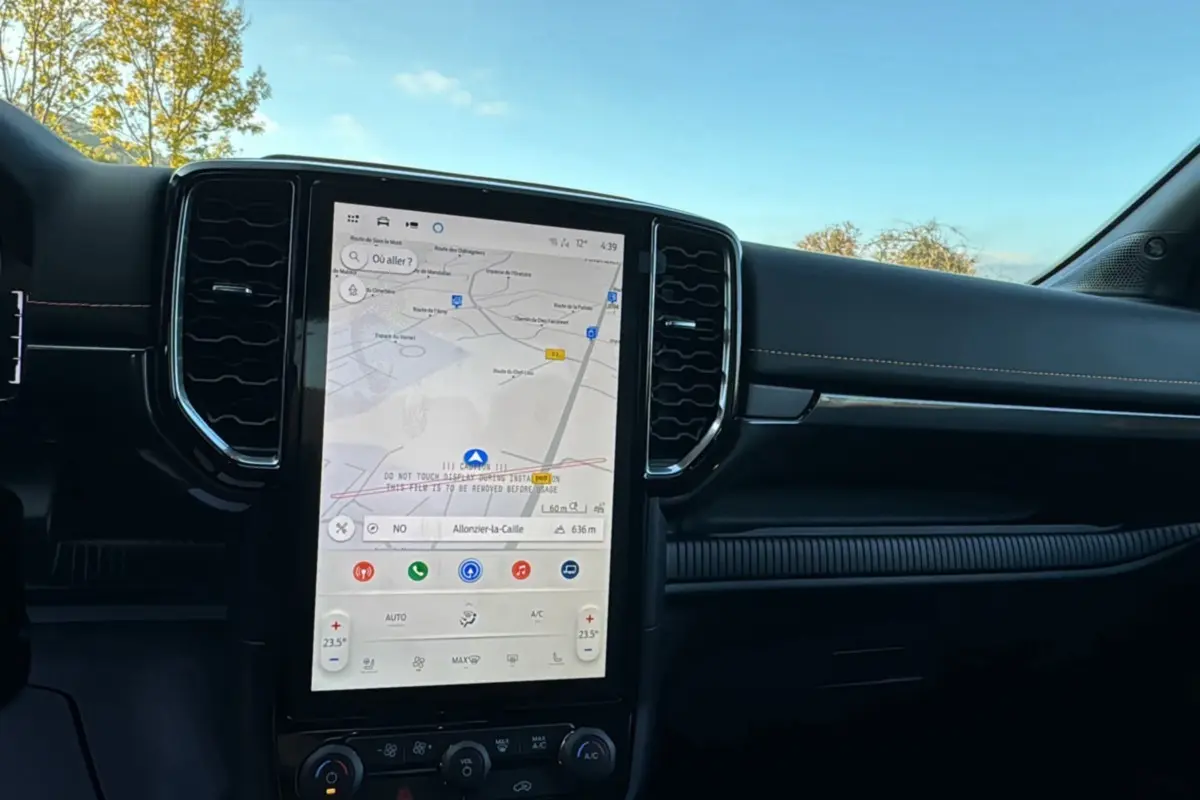Vue intérieure du tableau de bord du Ford Ranger PHEV 281 Wildtrak avec écran tactile central et finition noire.