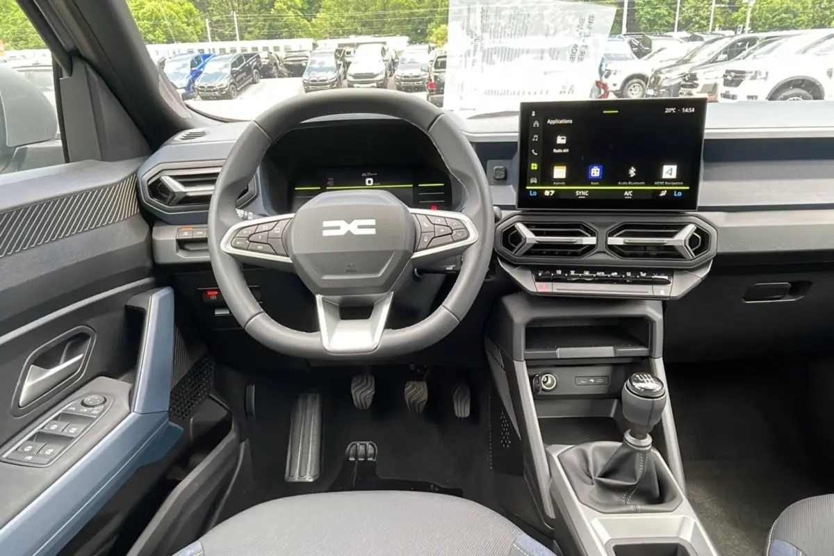 Vue intérieure avant du tableau de bord du Dacia Bigster 2025 avec volant cuir et écran tactile central.
