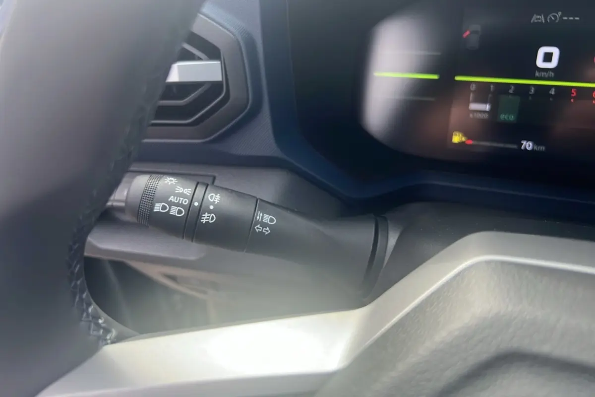 Gros plan sur la commande des feux et clignotants à gauche du volant dans le tableau de bord du Dacia Bigster 2025.