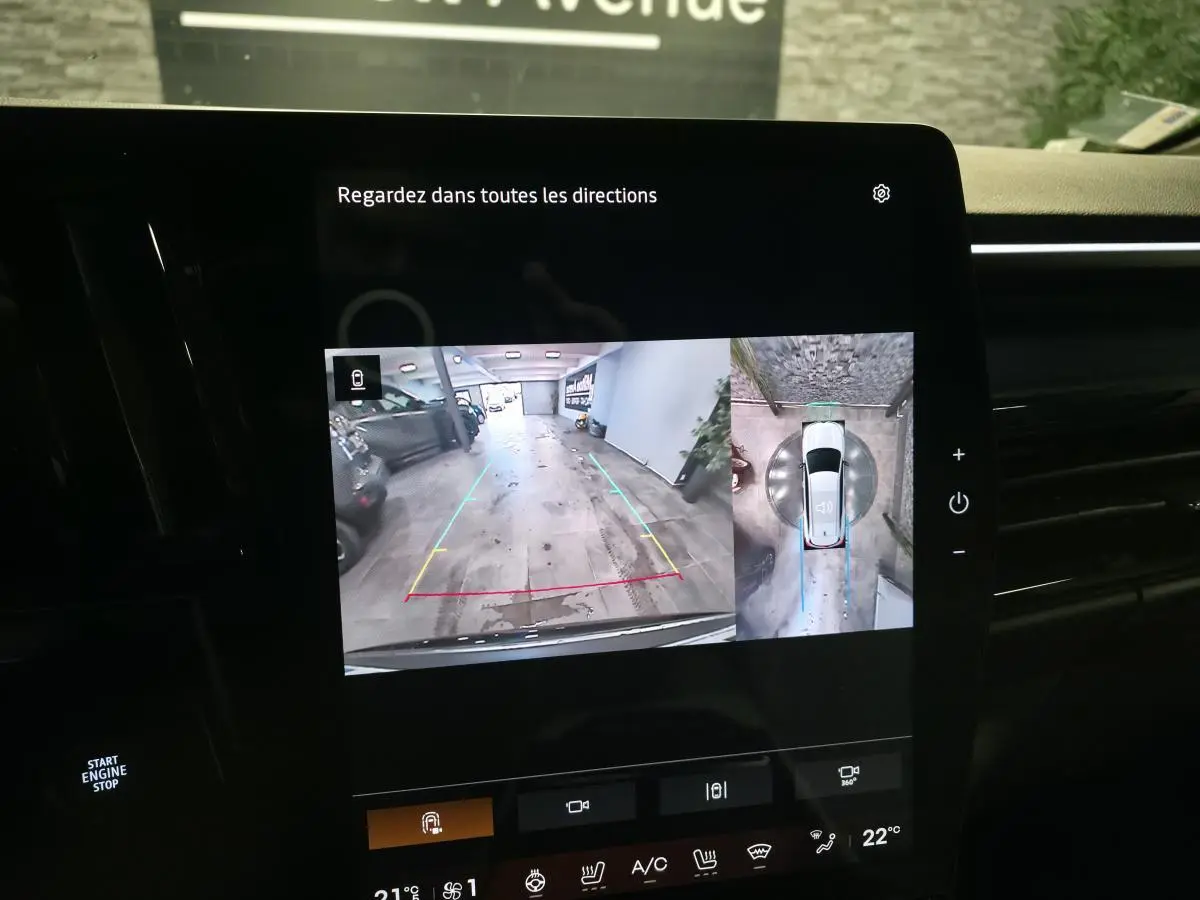 Écran multimédia montrant la caméra de recul et vue 360° d'une Renault Espace gris Baltique en stationnement intérieur.