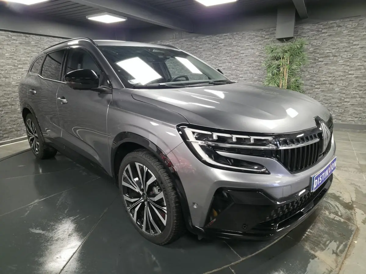 Renault Espace 2025 gris Baltique en 3/4 avant droit, avec calandre noire brillante et jantes alliage 20 pouces.