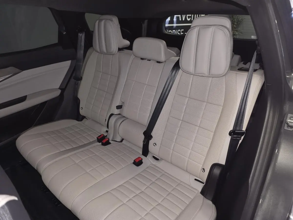 Banquette arrière beige clair en textile refined avec surpiqûres marron visible côté droit du Renault Espace gris 2025.