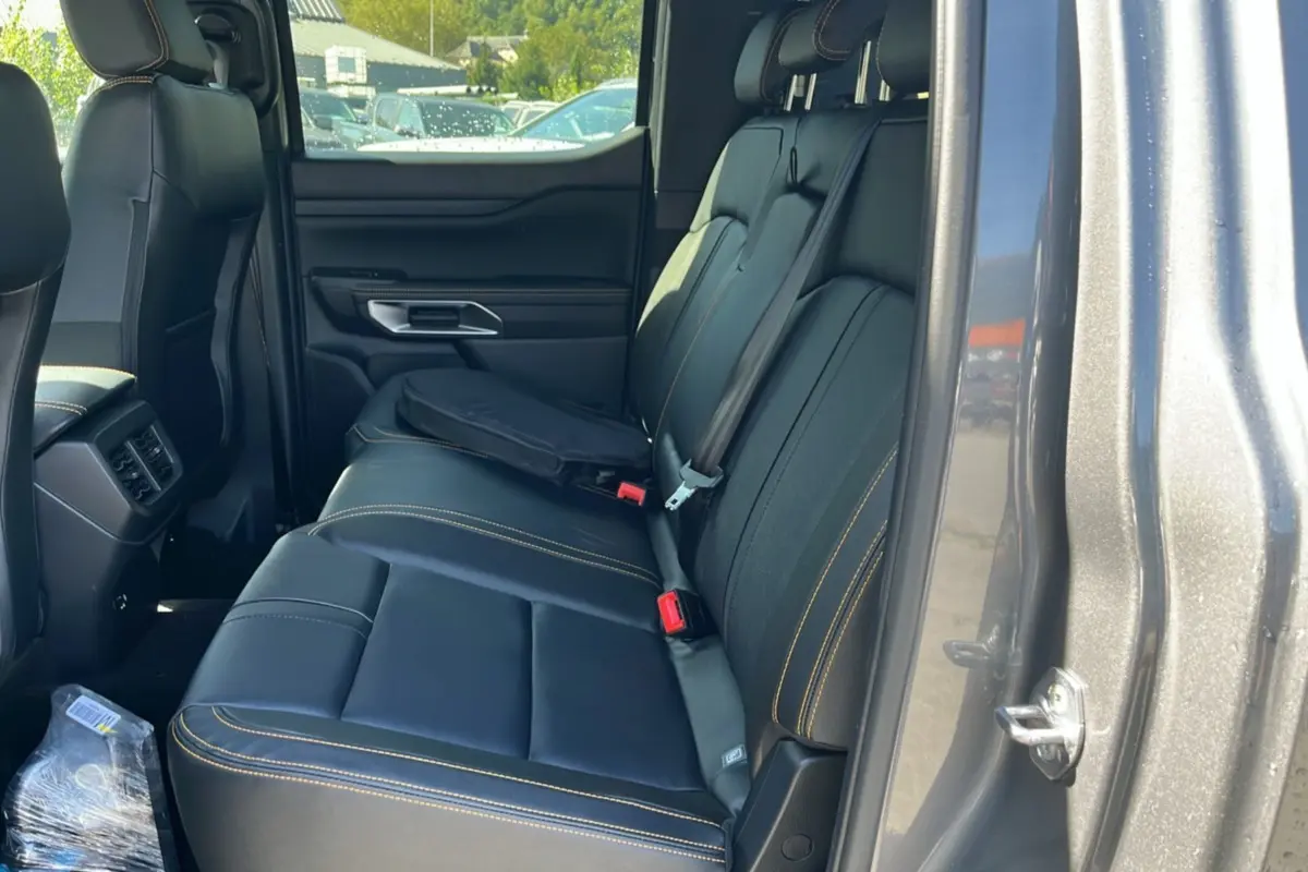 Vue intérieure côté droit sur la banquette arrière en cuir noir avec surpiqûres jaunes du Ford Ranger gris carbone 2025 PHEV Wildtrak.