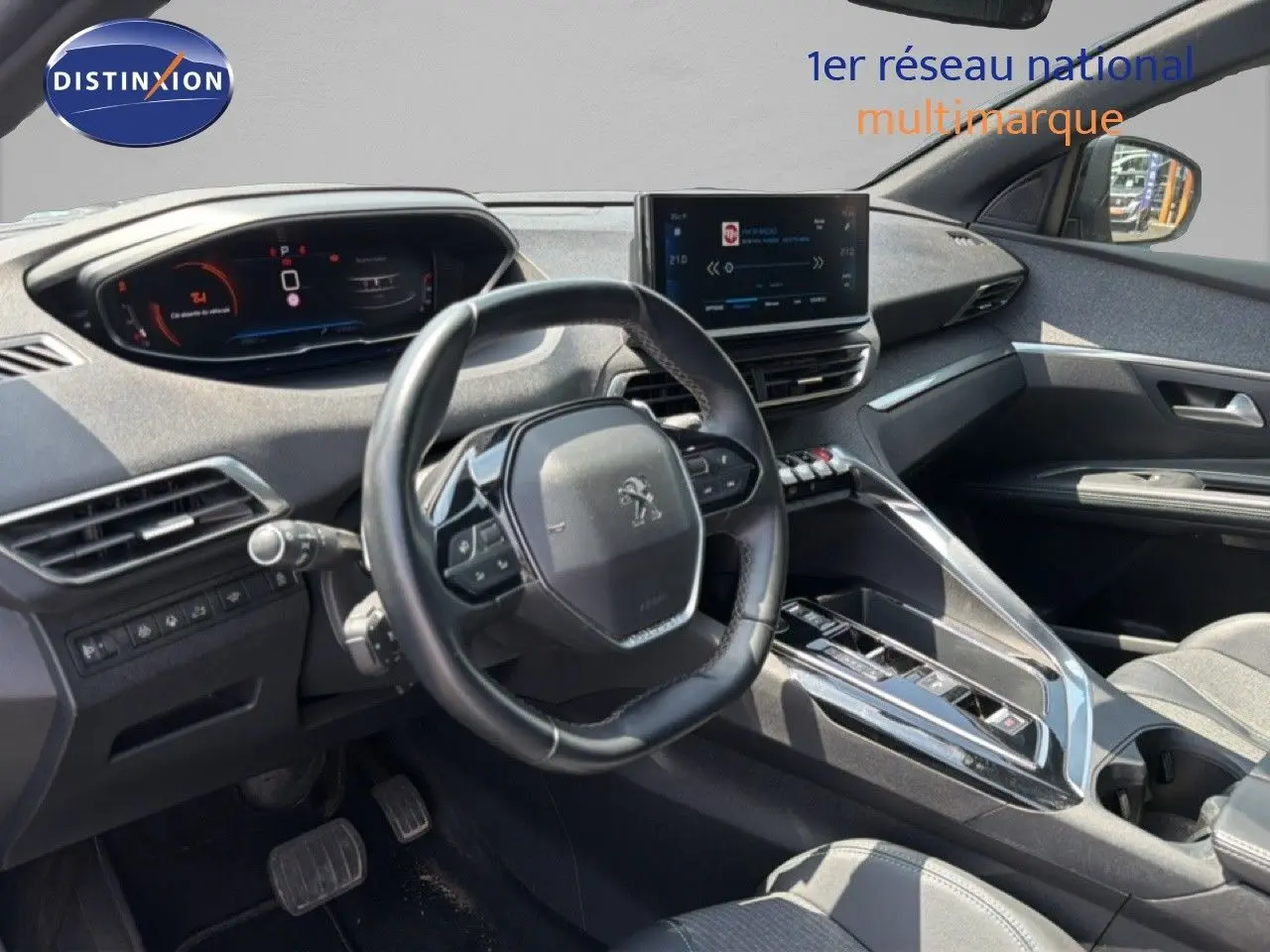 Vue intérieure côté conducteur du Peugeot 5008 2023, tableau de bord et volant compact avec écran tactile central.