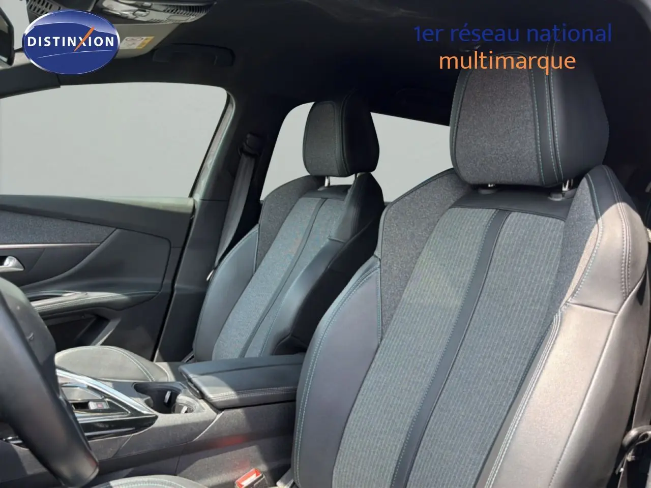 Vue intérieure côté avant droit du Peugeot 5008 2023, sièges tissu et cuir noir avec surpiqûres bleues.
