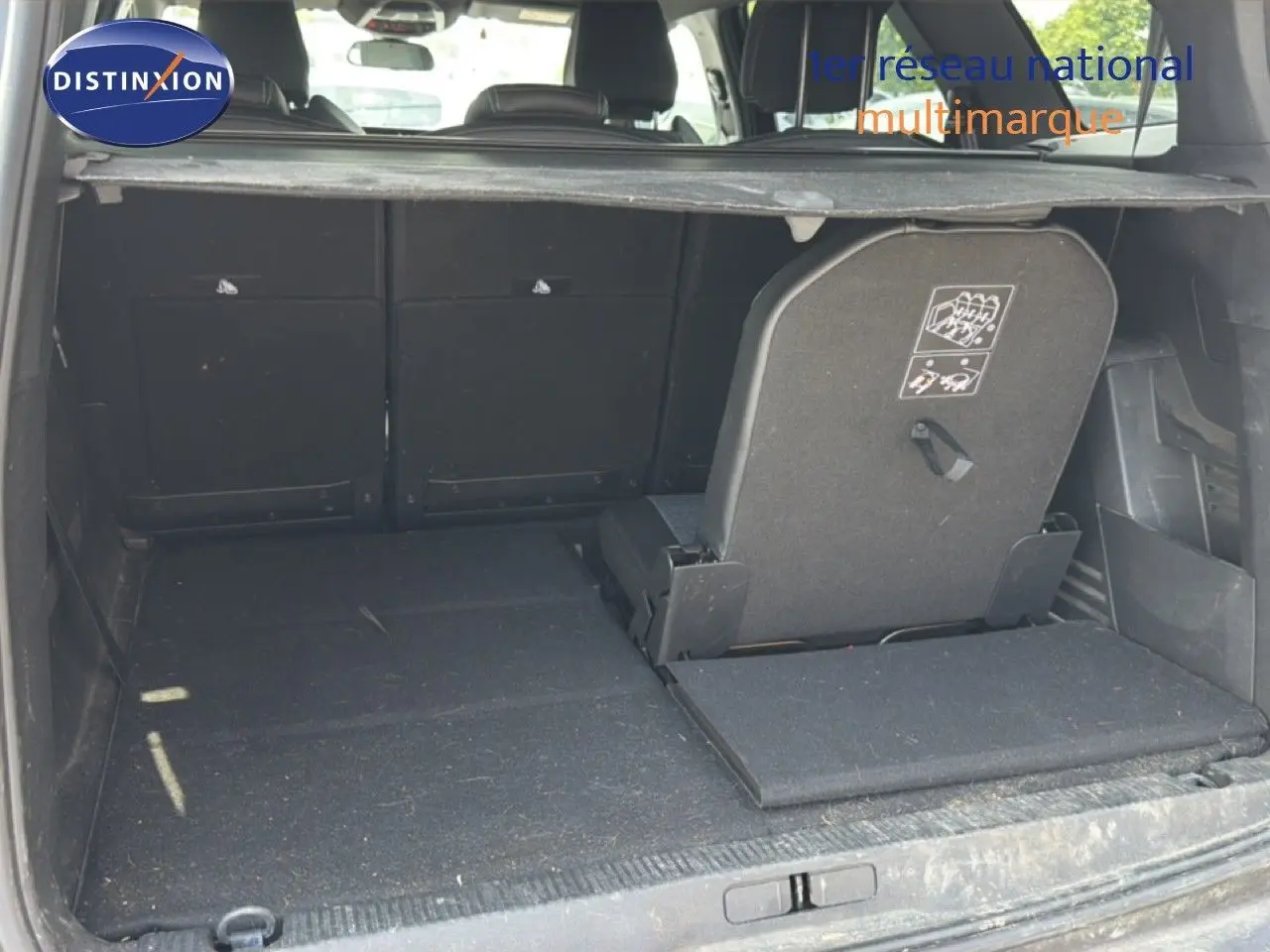 Coffre ouvert du Peugeot 5008 gris Platinium, vue arrière montrant la banquette arrière partiellement rabattue.