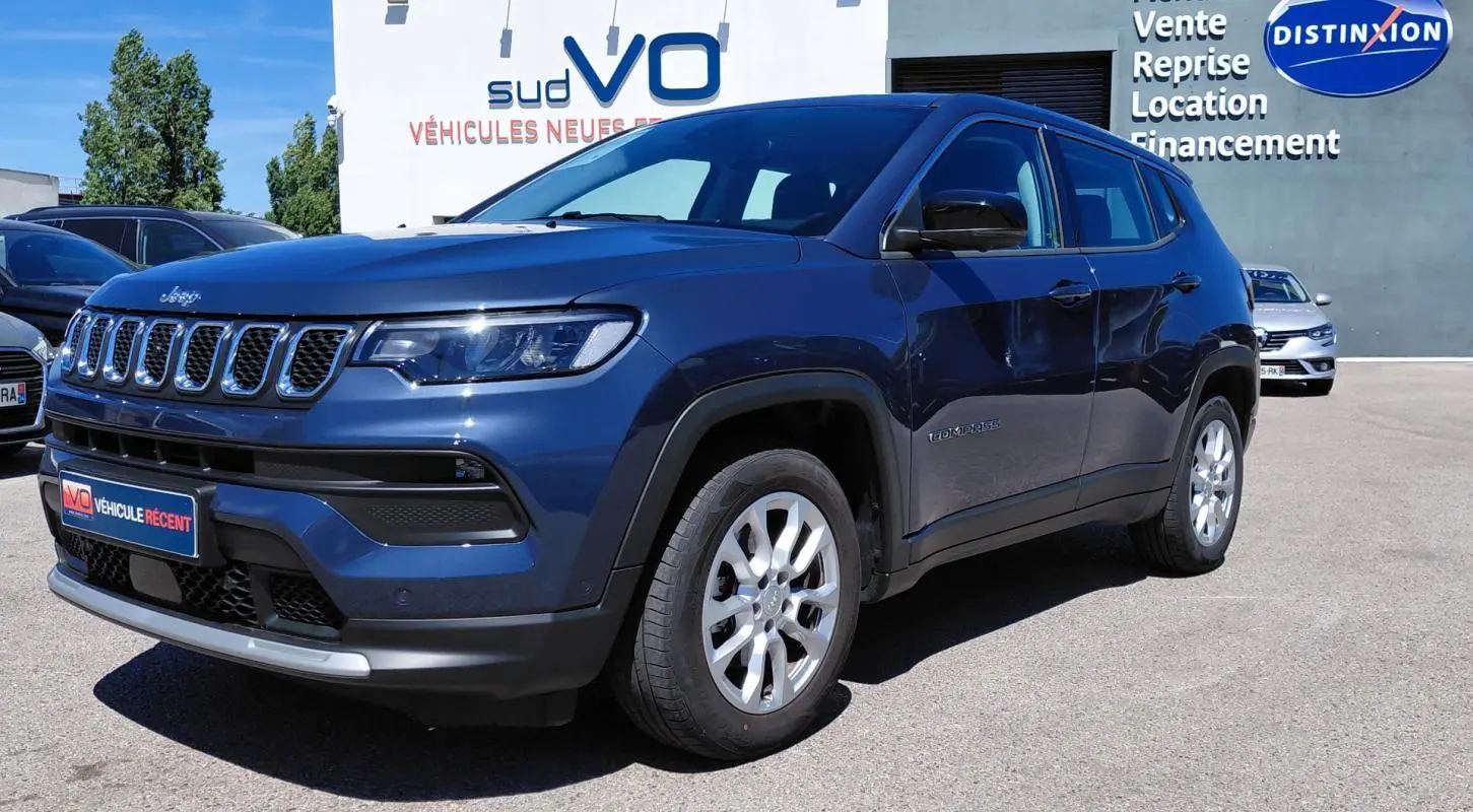 Jeep Compass bleu en 3/4 avant droit, avec calandre distinctive et jantes alliage 18 pouces visibles.