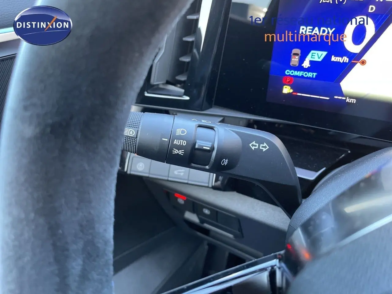 Détail du commodo d'éclairage et clignotants côté gauche du volant dans le cockpit du Renault Austral noir étoile métal.
