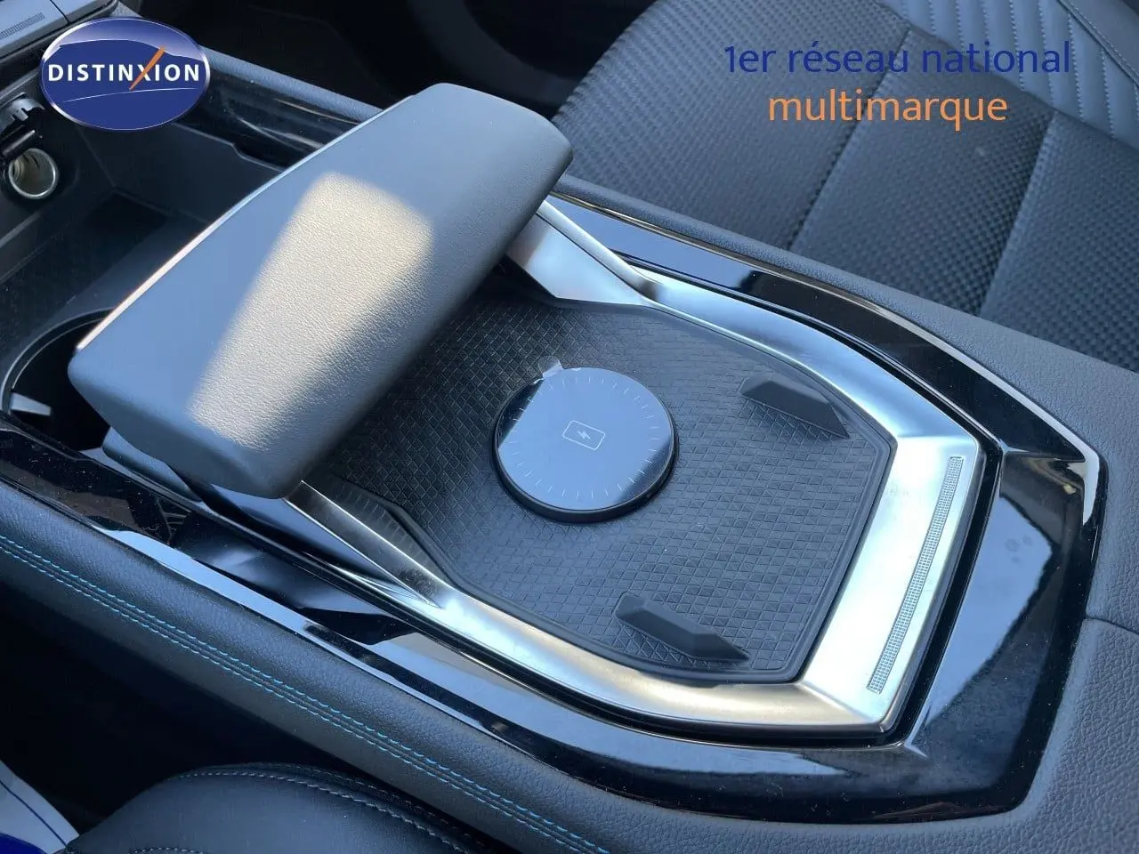 Vue rapprochée de la console centrale noire étoile métal du Renault Austral E-Tech hybride avec accoudoir et surface de recharge.