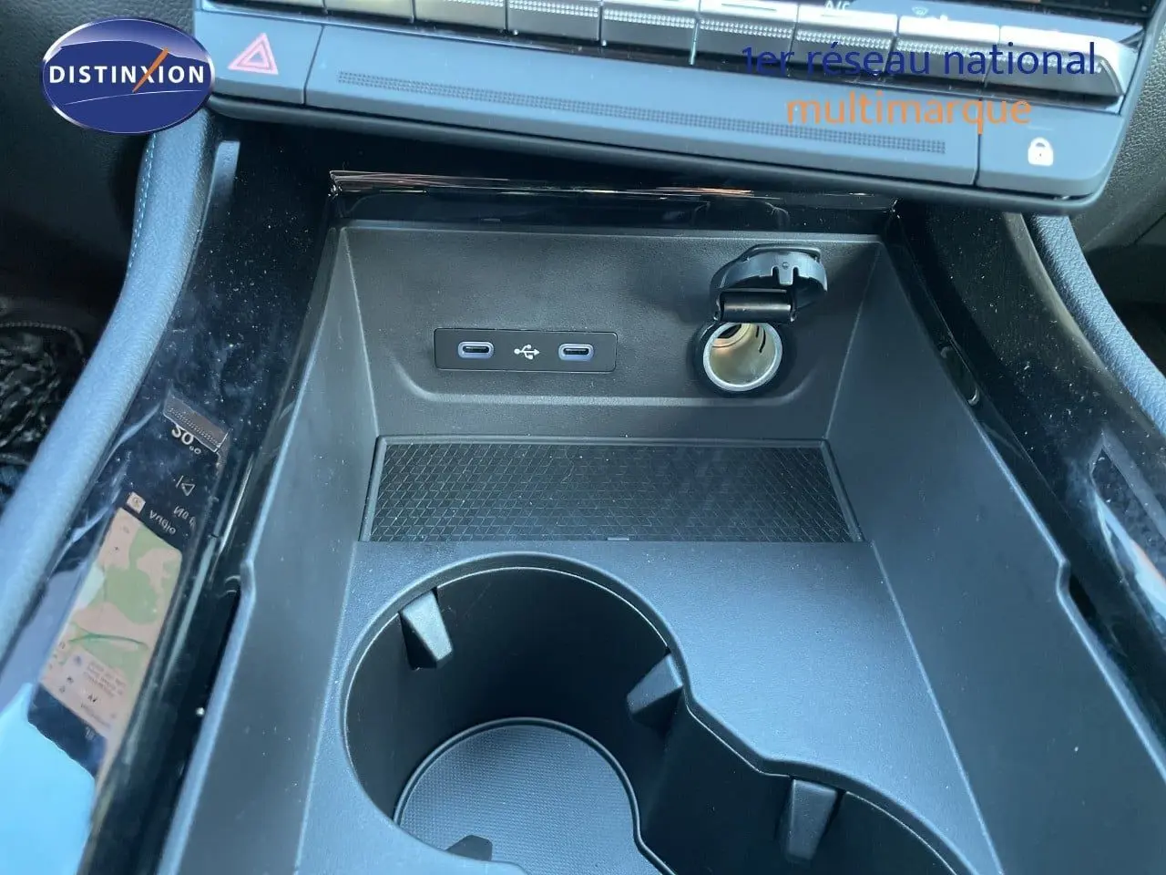 Gros plan sur la console centrale noire du Renault Austral 2026, montrant prises USB, allume-cigare et porte-gobelets.