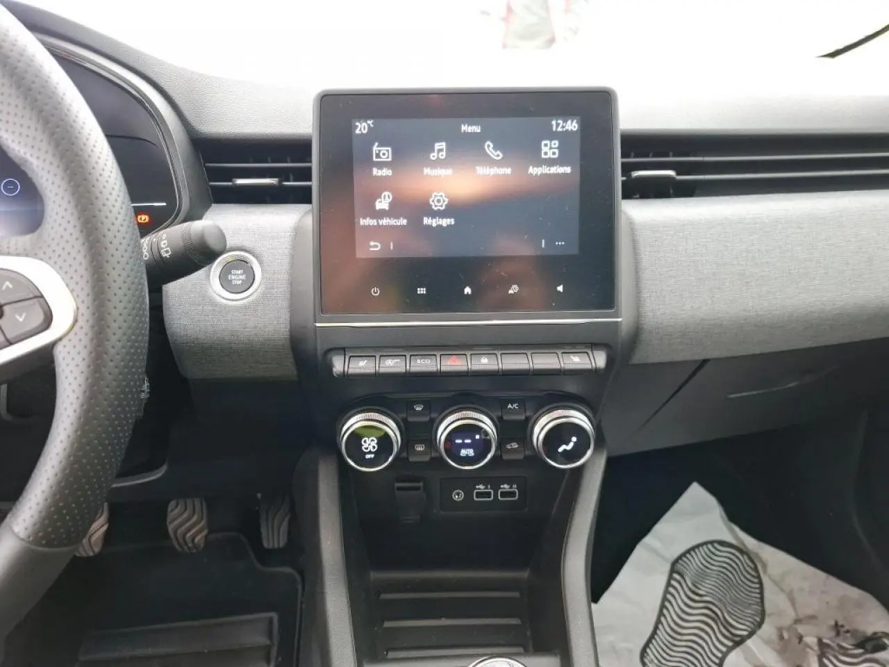 Vue intérieure centrée sur la console centrale et l'écran tactile 7 pouces de la Renault Clio blanche 2024.