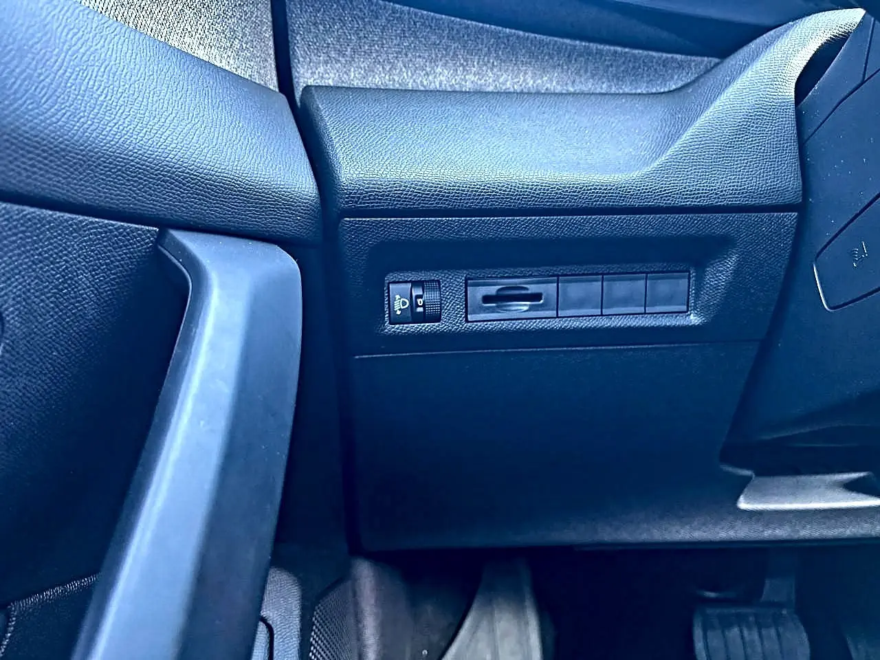 Détail intérieur côté gauche avec commandes d’éclairage sur tableau de bord noir de Peugeot 308 2025.