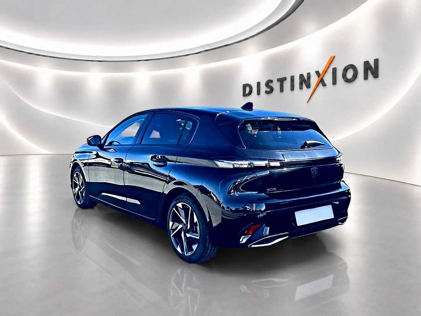 Peugeot 308 noire vue 3/4 arrière droit en intérieur, avec jantes alu et feux arrière LED distinctifs.