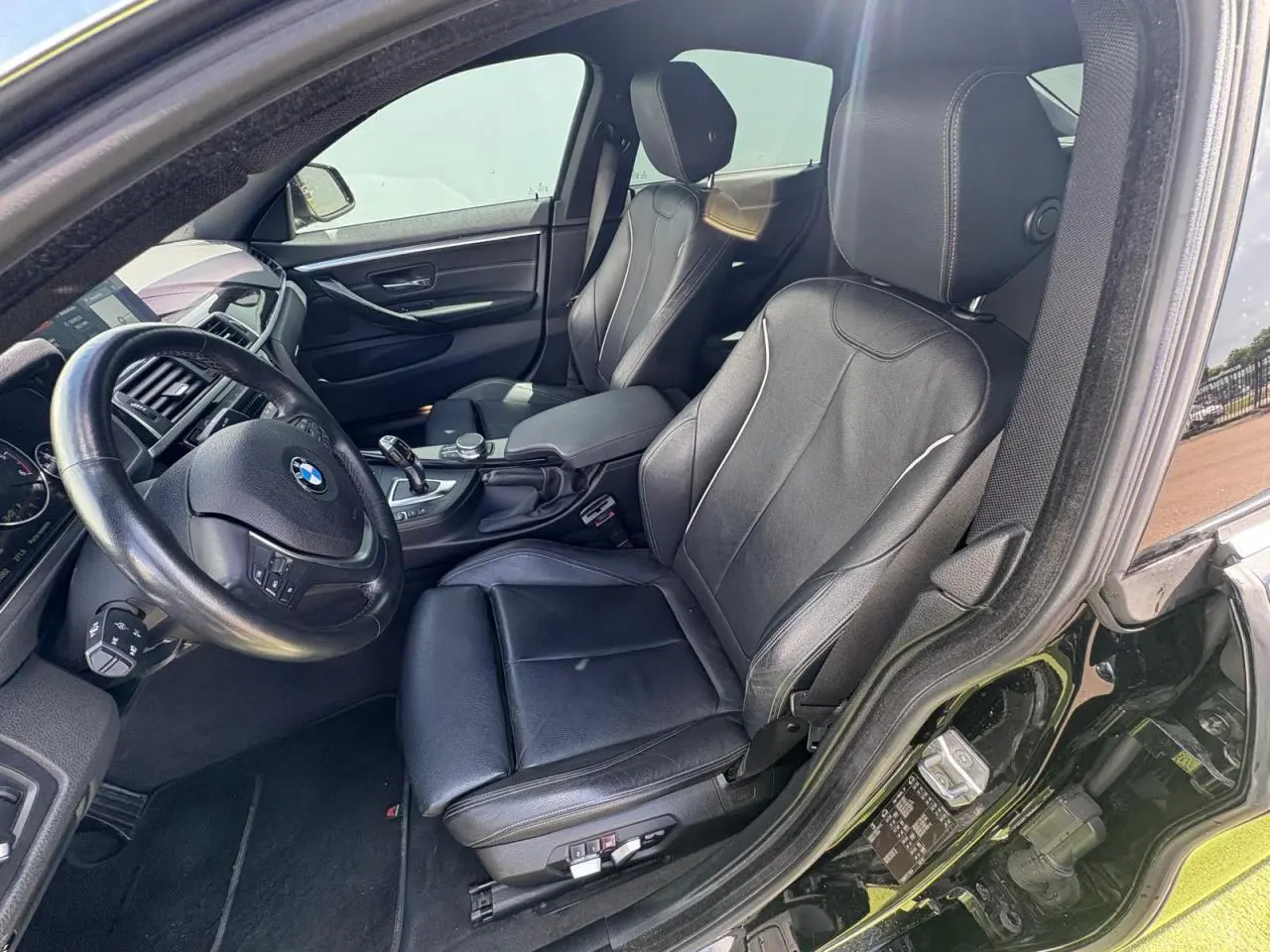 Intérieur côté conducteur de BMW Série 4 Gran Coupé noir saphir, sièges cuir Dakota et volant sport multifonctions.