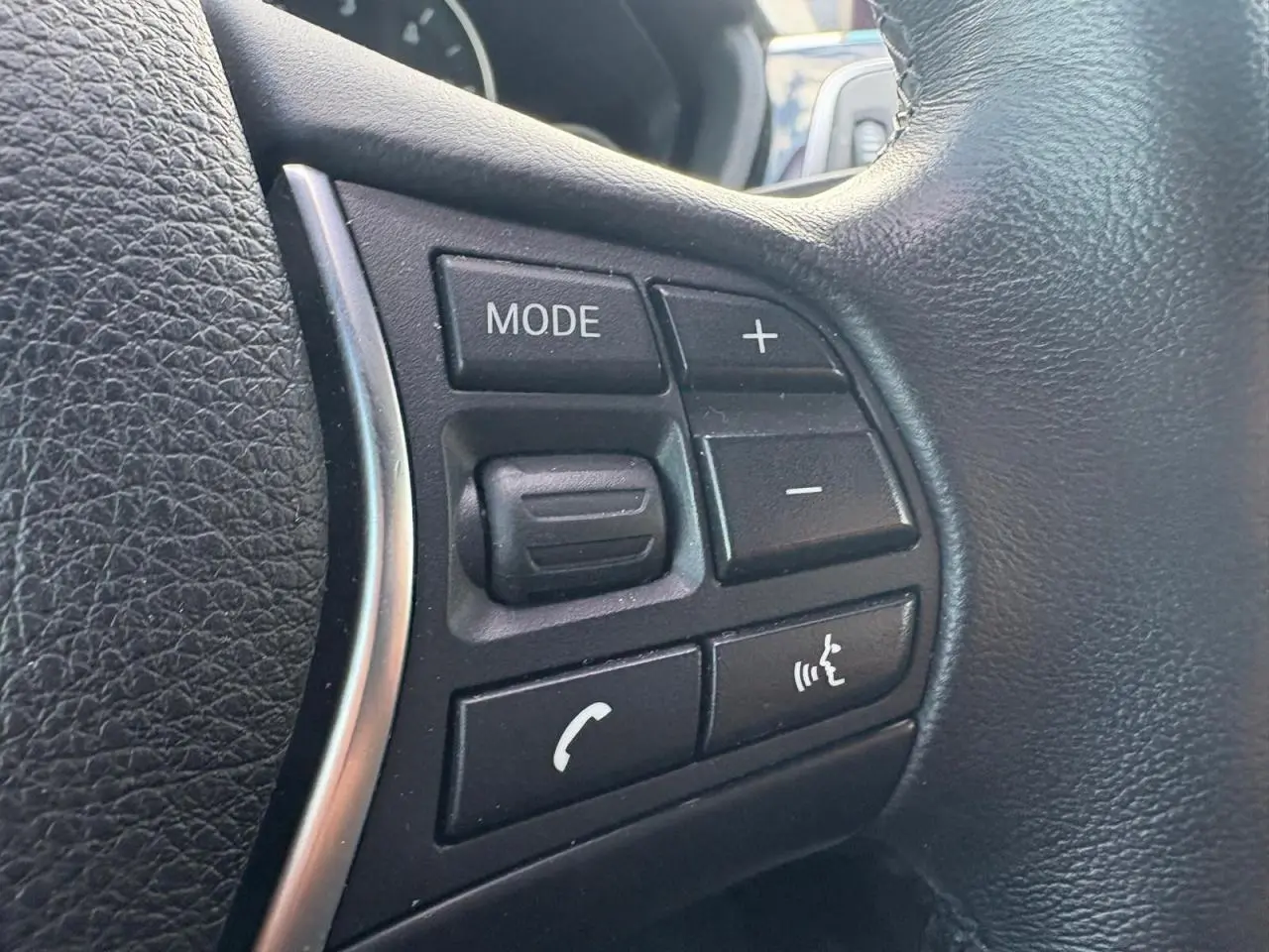 Gros plan sur les commandes multifonctions en cuir noir du volant de la BMW Série 4 Gran Coupé 420d.