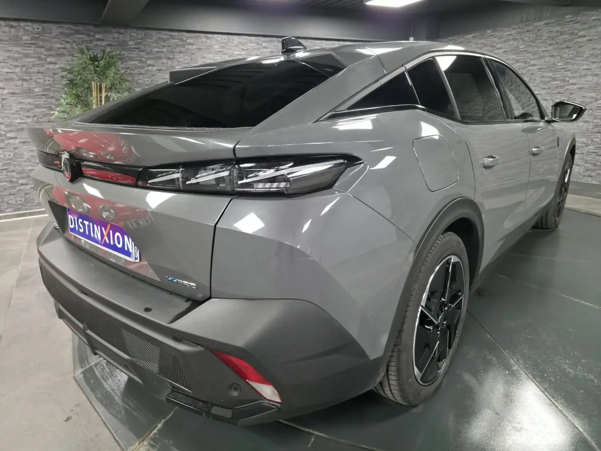 Vue 3/4 arrière droite du Peugeot 408 gris métallisé avec feux arrière à LED et jantes alliage noires.