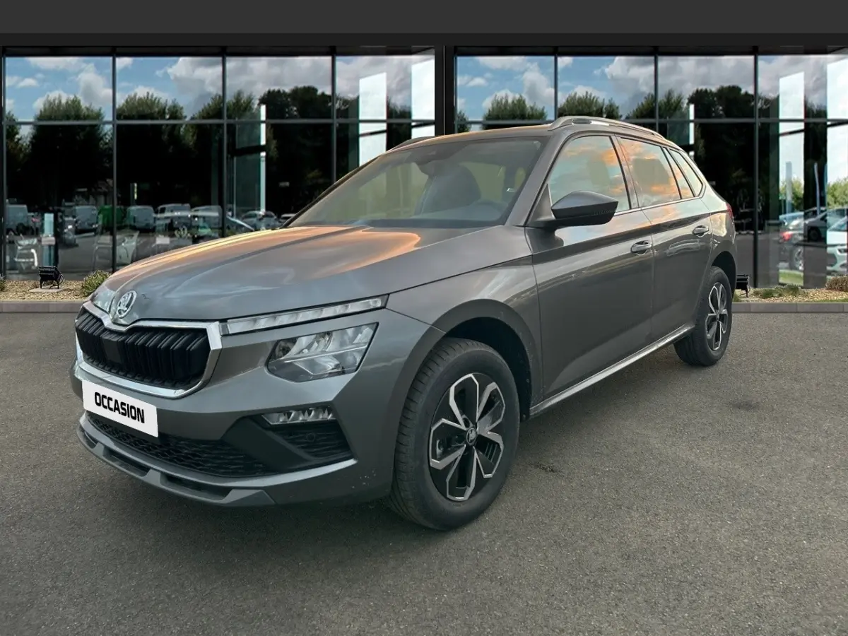 Vue 3/4 avant d'un Skoda Kamiq gris clair 2025 avec calandre noire et jantes au design moderne.