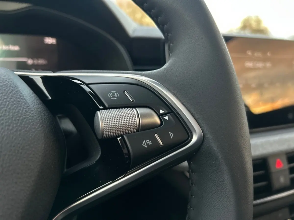 Gros plan sur les commandes multifonctions en aluminium du volant cuir du Skoda Kamiq gris clair 2025.