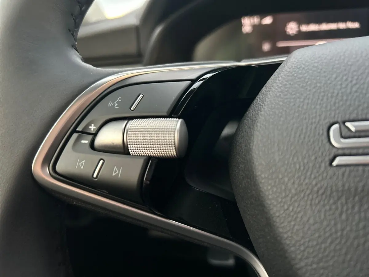 Gros plan sur la commande multifonctions gauche du volant cuir noir du Skoda Kamiq gris clair 2025.