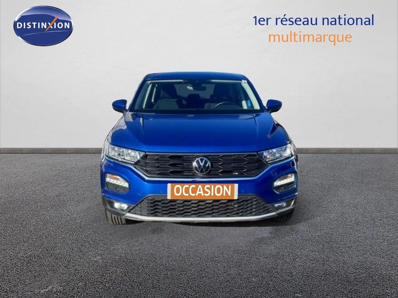 Vue frontale d'un Volkswagen T-Roc bleu Ravenna metal avec calandre noire et plaque "OCCASION" orange.
