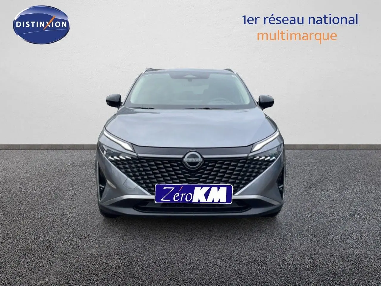 Vue frontale d'un Nissan Qashqai 1.5 E-POWER gris squale métal avec calandre noire et phares LED fins.