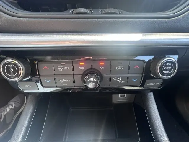 Vue rapprochée de la console centrale noire du Jeep Compass 2025, montrant les commandes de climatisation et multimédia.