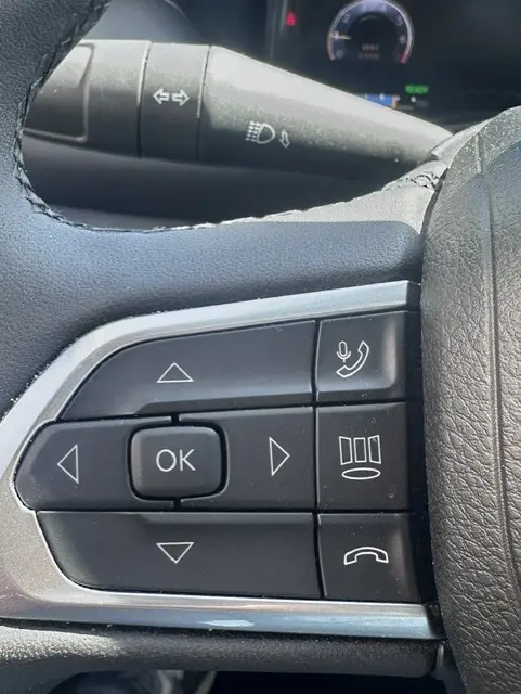 Gros plan sur les commandes multifonctions au volant du Jeep Compass noir 2025, avec boutons de navigation et téléphone.