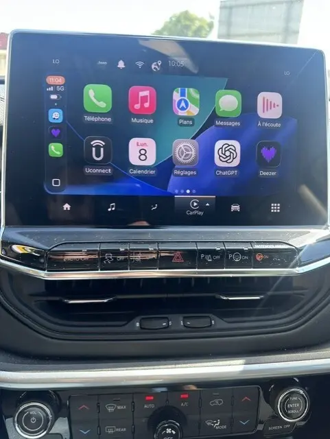 Écran tactile central du Jeep Compass 2025 montrant interface Apple CarPlay avec commandes climatisation et multimédia en dessous.