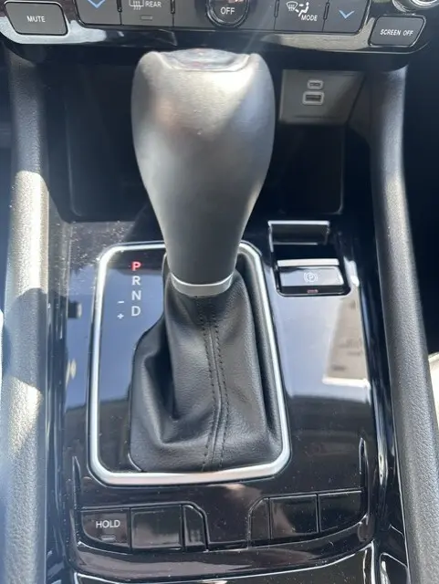 Gros plan sur le levier de vitesses automatique noir du Jeep Compass 2025 avec bouton frein à main électronique et commandes autour.