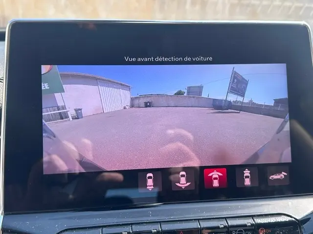 Écran tactile affichant la caméra de recul du Jeep Compass noir, vue arrière avec détection de voiture en parking.