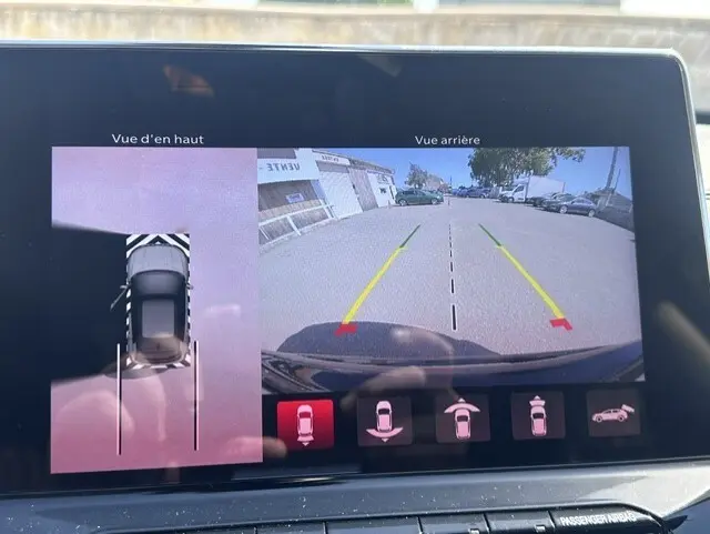 Écran tactile montrant la caméra de recul et vue aérienne du Jeep Compass noir 2025 avec lignes de guidage jaunes et rouges.