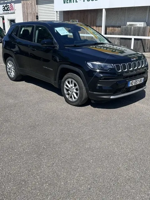 Jeep Compass noir en vue 3/4 avant droit, avec jantes alliage 18 pouces et calandre distinctive à sept fentes.
