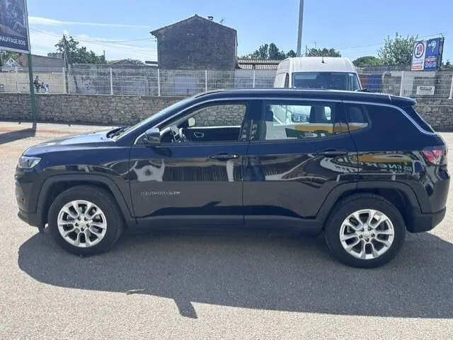 Vue latérale droite d'un Jeep Compass noir 2025 avec jantes alliage 18 pouces, profil compact et lignes épurées.