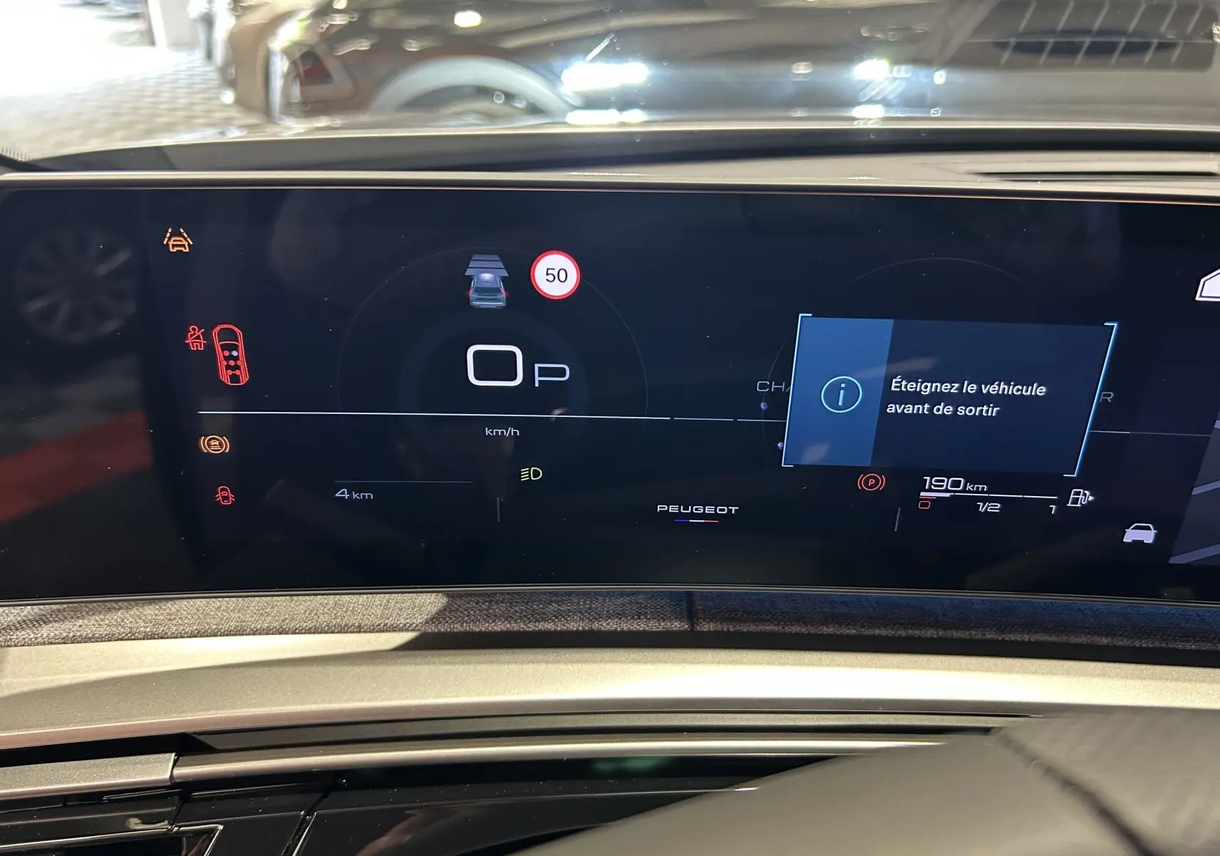 Tableau de bord numérique du Peugeot 5008 III GT Hybrid 145, affichant la vitesse à 0 km/h et alertes actives.