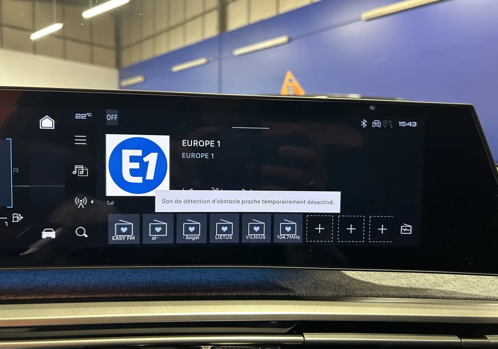 Écran tactile central du tableau de bord du Peugeot 5008 III GT Hybrid 145, affichant la radio Europe 1.