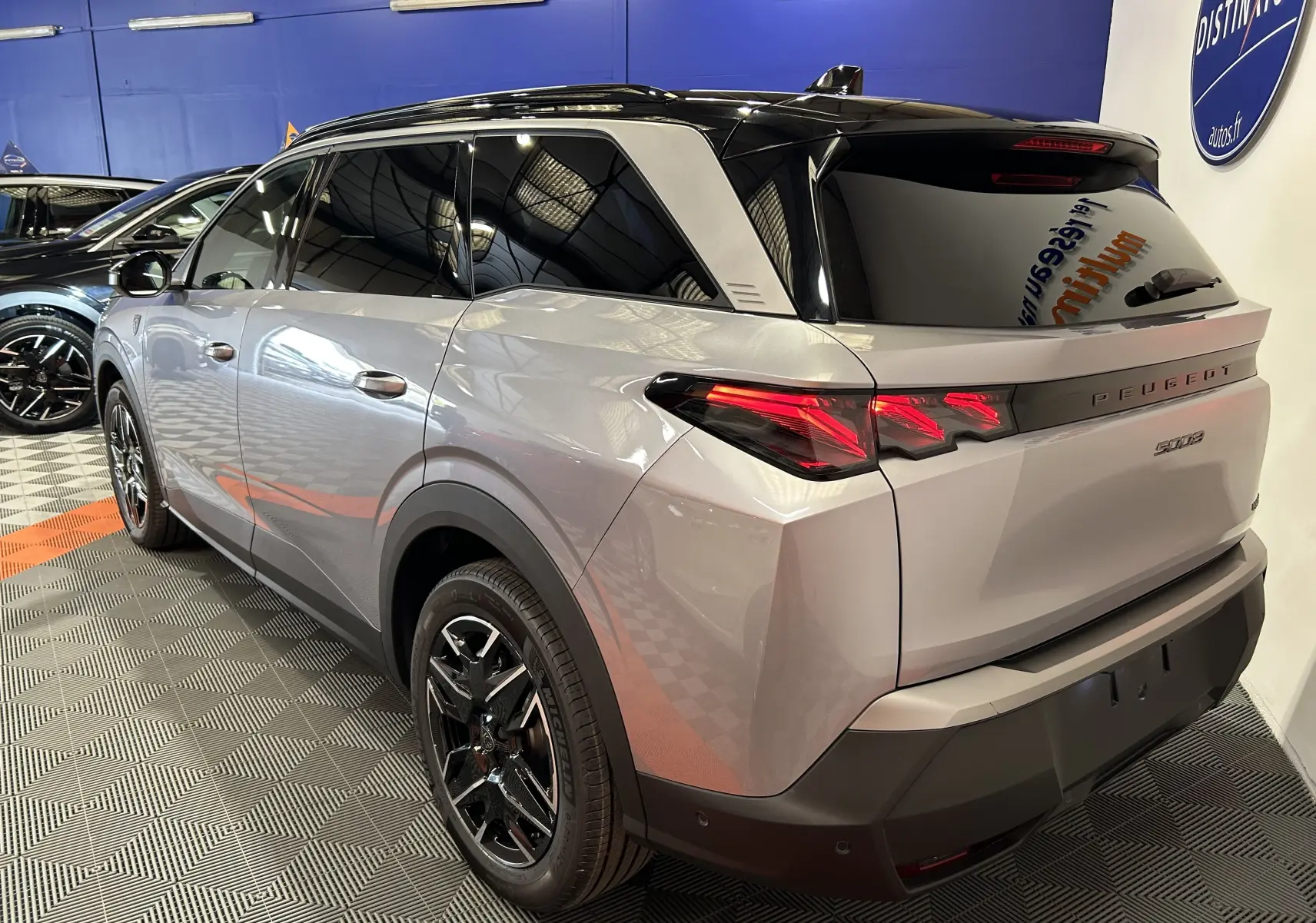 Vue 3/4 arrière droite du Peugeot 5008 gris Artense avec toit noir et feux arrière LED distinctifs.