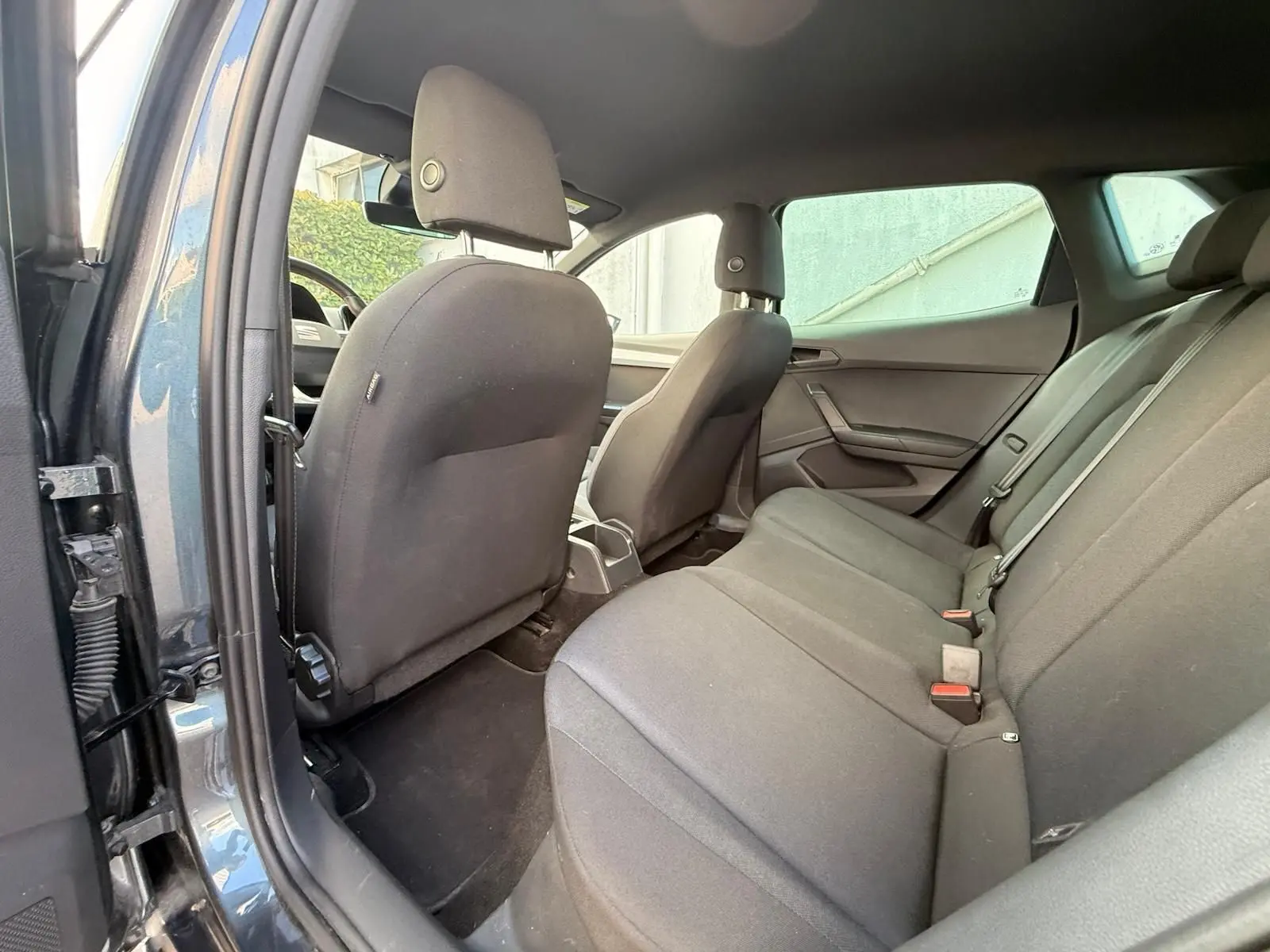 Vue intérieure du siège arrière côté droit d'une SEAT Ibiza 1.0 TSI 95 FR gris foncé avec sellerie tissu noire.