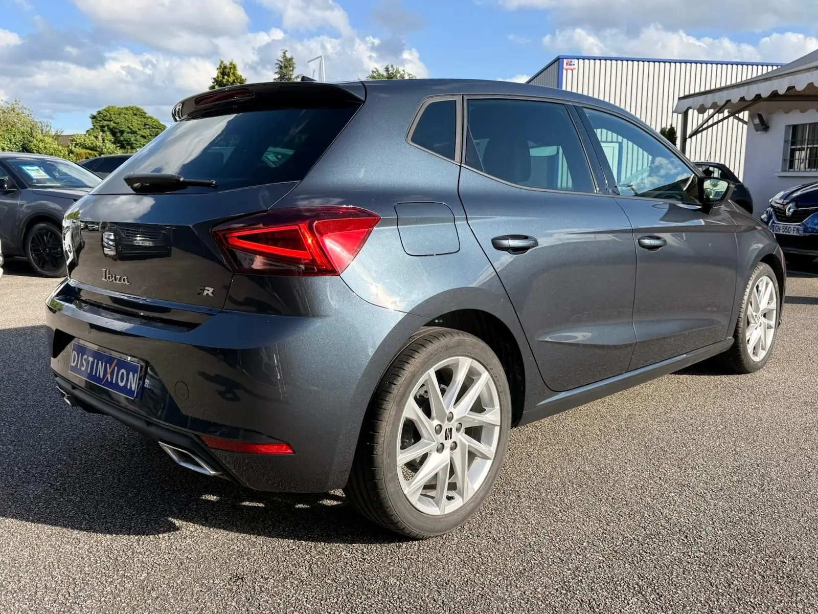 Vue 3/4 arrière droite d'une SEAT Ibiza 1.0 TSI 95 FR gris foncé avec jantes alliage et feux LED distinctifs.